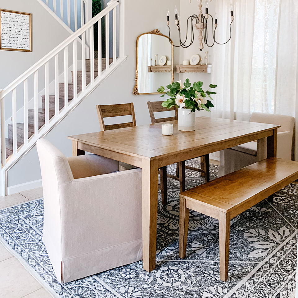 Almana floral rug in the dining room with wooden dining table and bench and flower vase