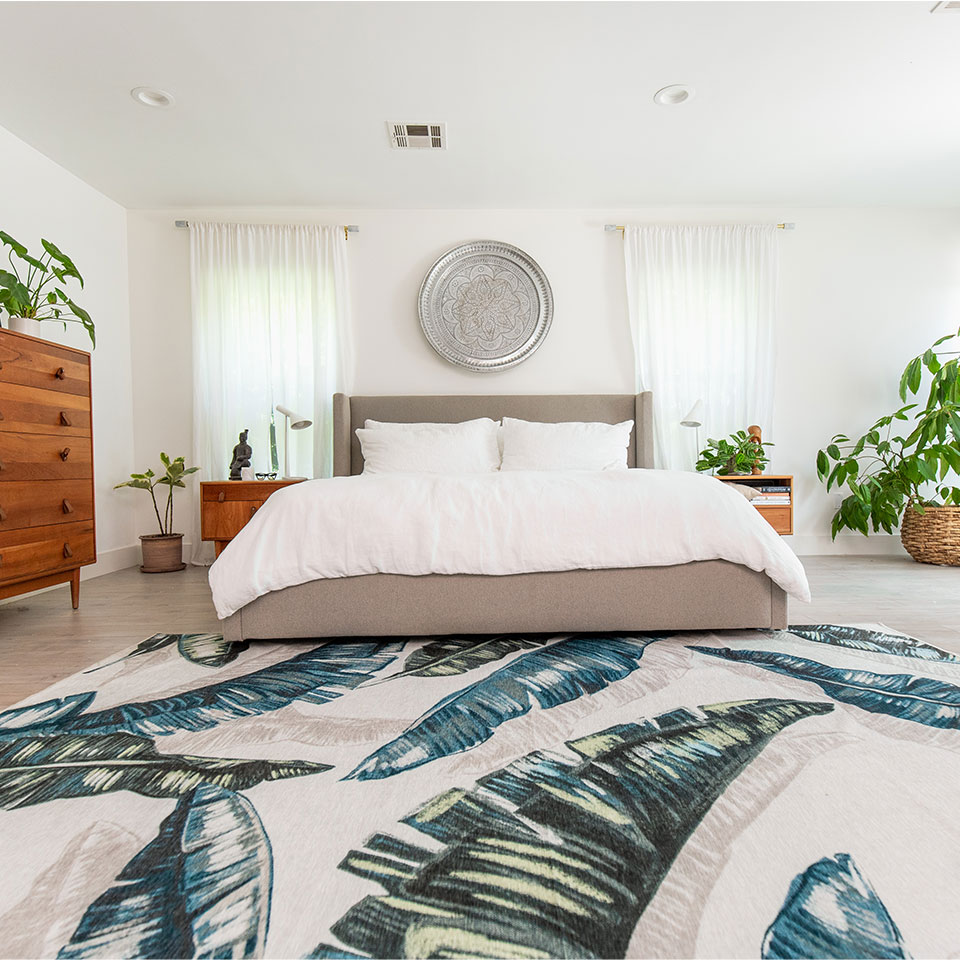 Green and white leaf rug with plants in bedroom