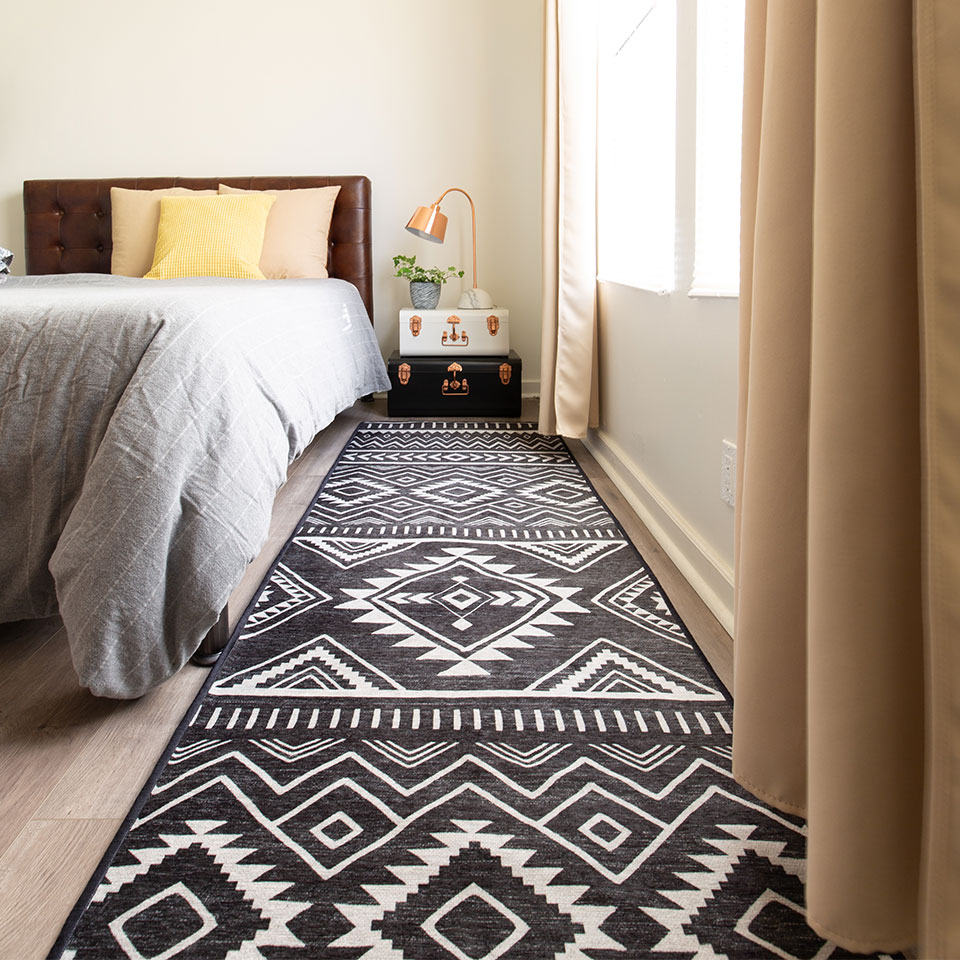 black and white dorm rug by bed