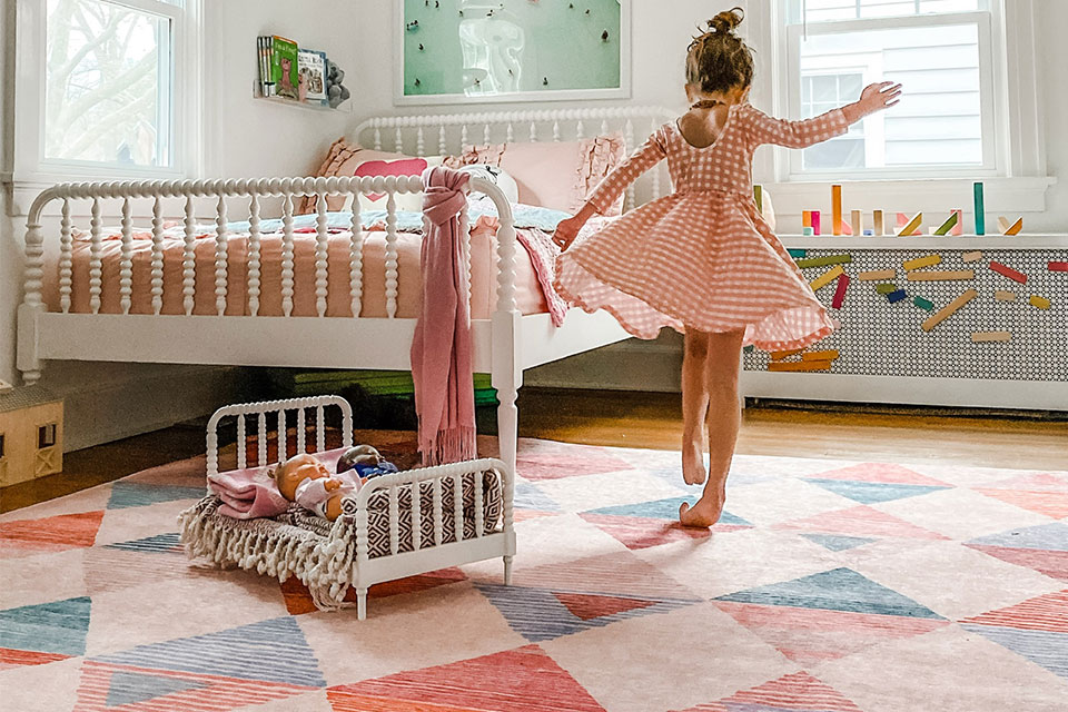 Pink and orange rug with triangles in girls bedroom