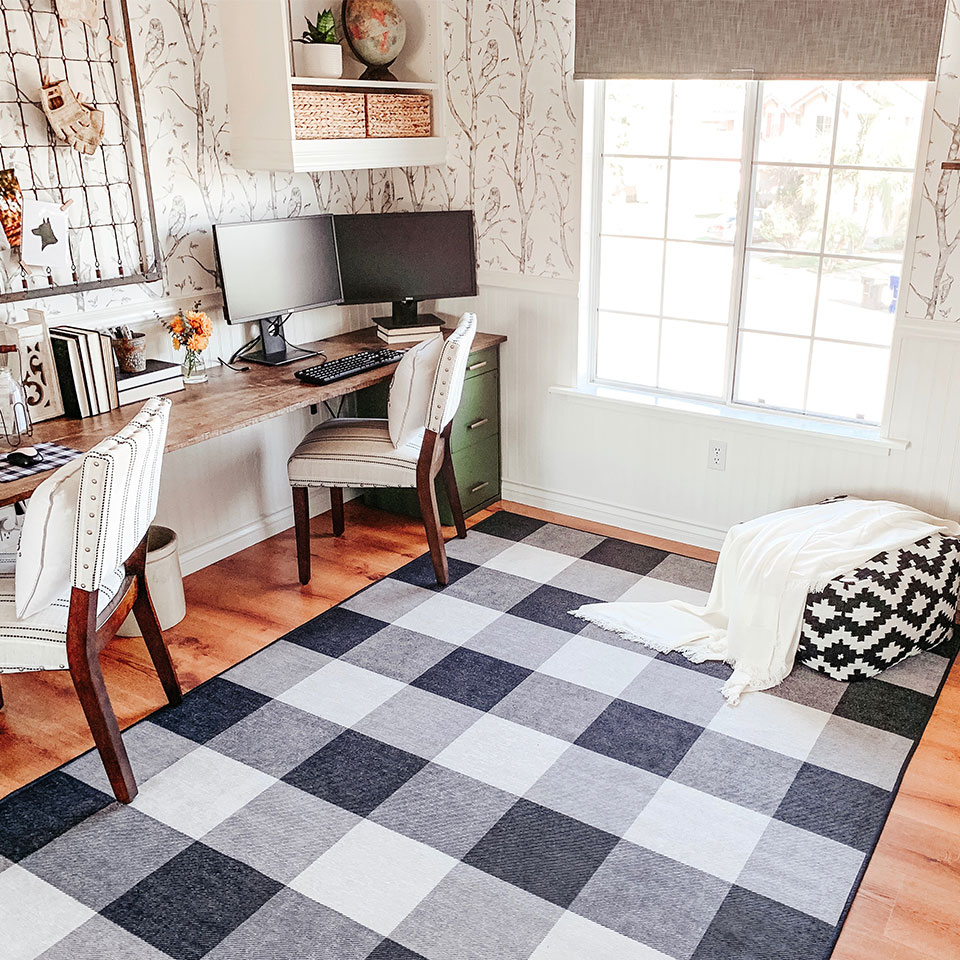 Black and white checkered rug in the home office with ottoman and vine wallpaper
