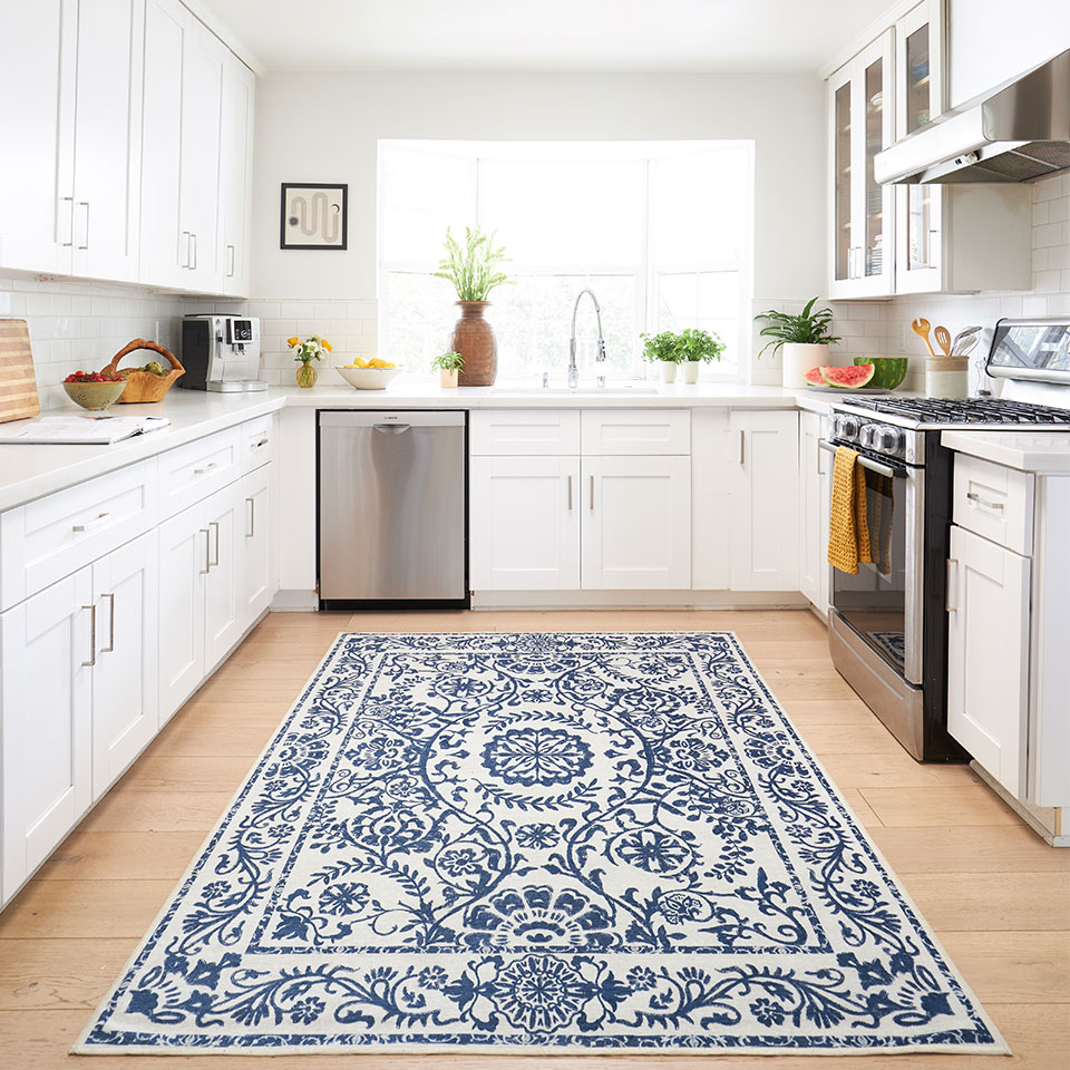 Blue and white 5x7 rug in medium kitchen with white cabinets