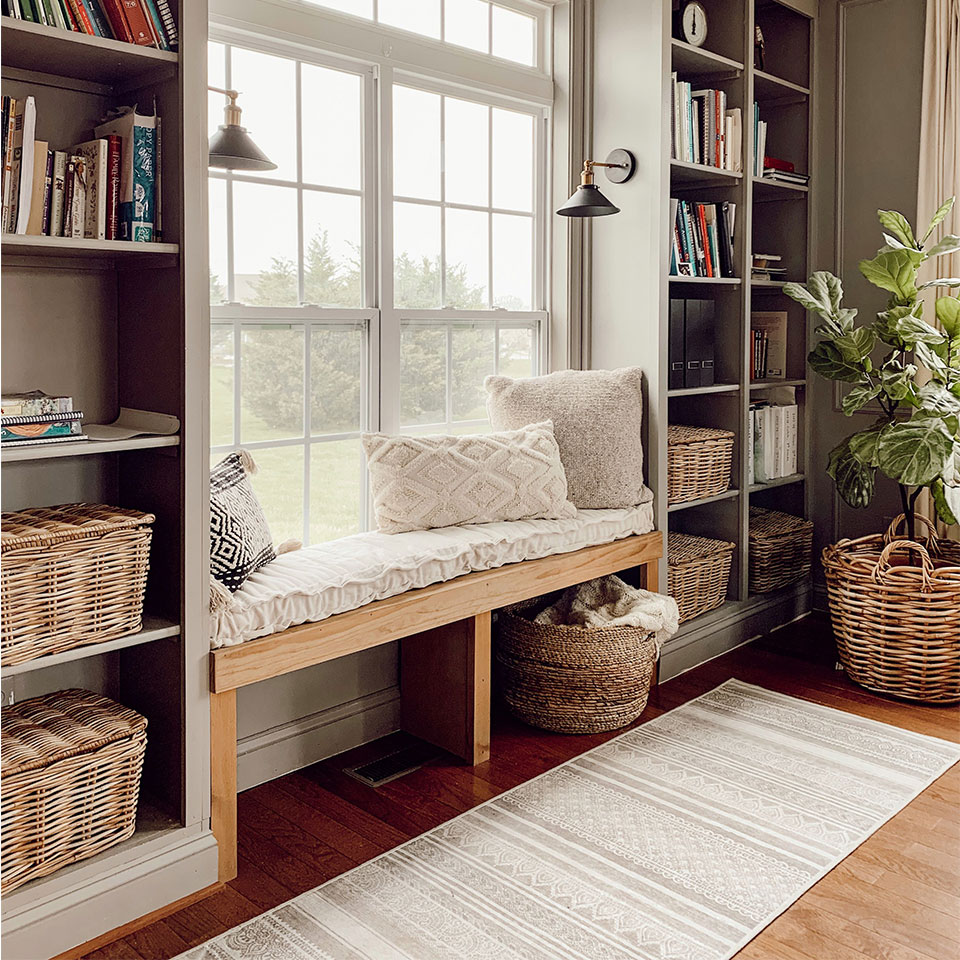 Grey striped geometric rug by bookshelves and reading nook