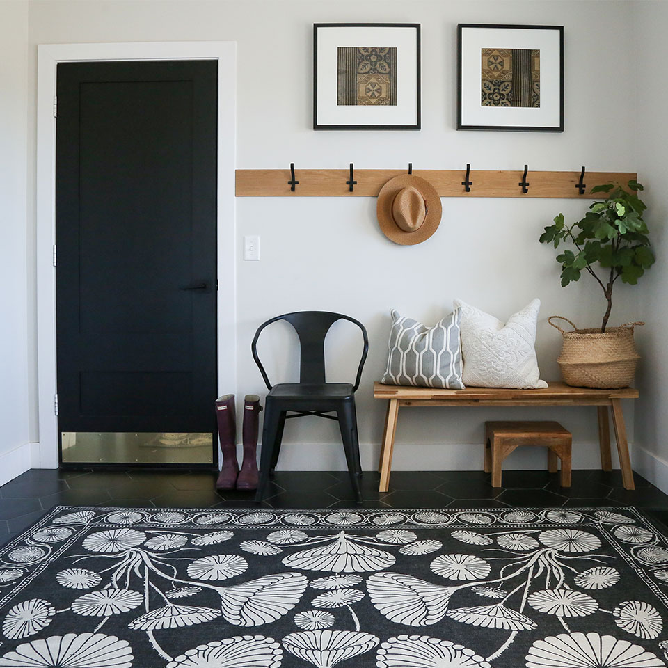Black and white floral rug in entryway.