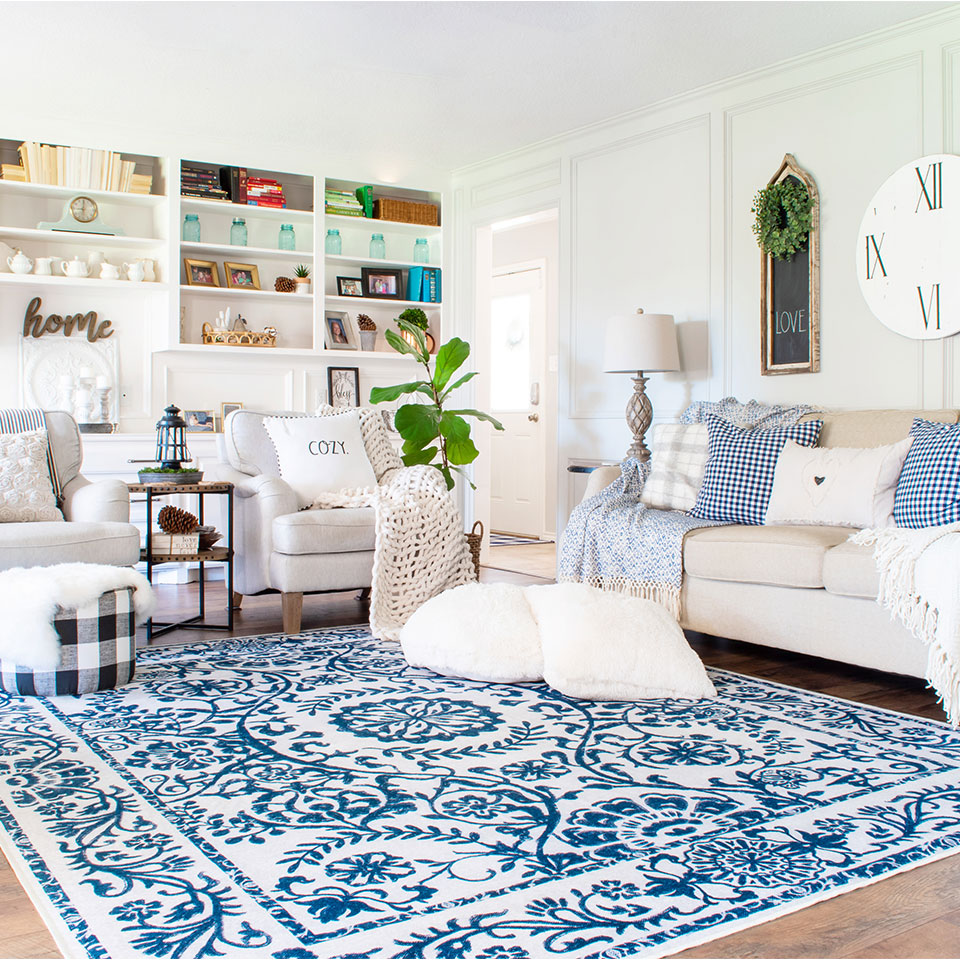 Blue and white floral rug with plaid throw pillows in living room