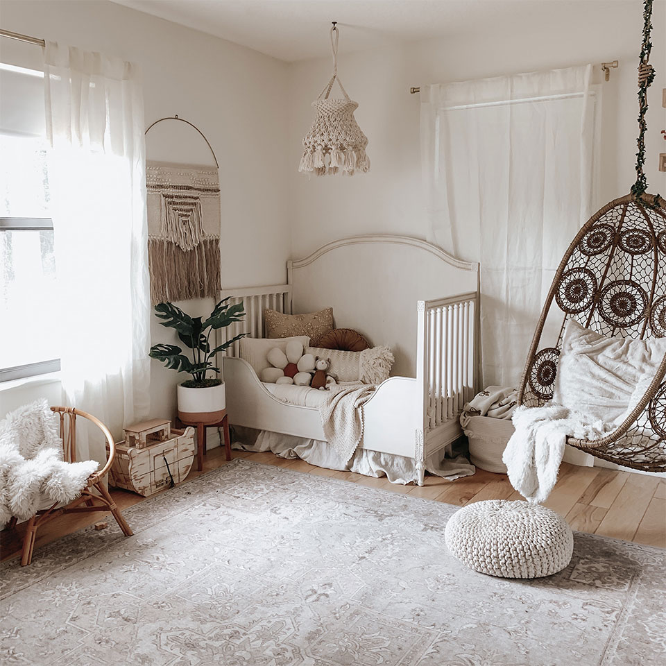 Cream vintage rug in bohemian nursery with hammock