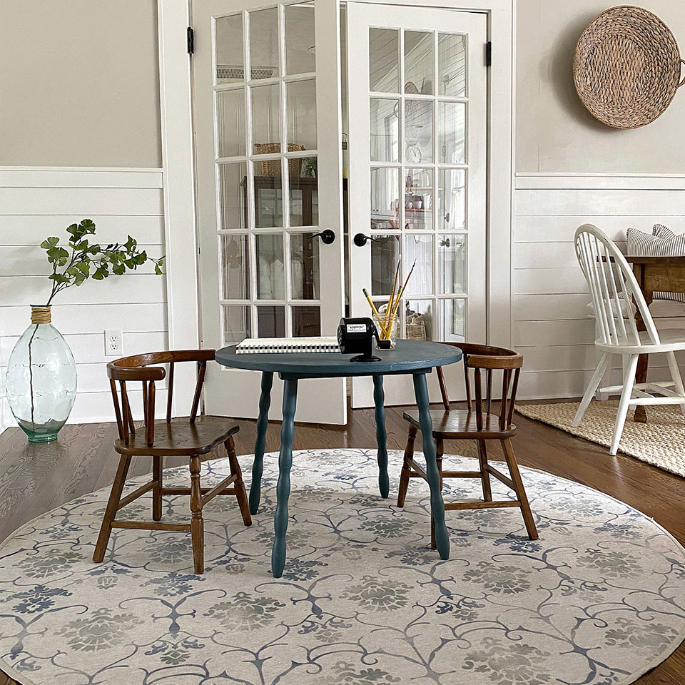 Blue cofee table and brown chairs on round floral rug in the living room