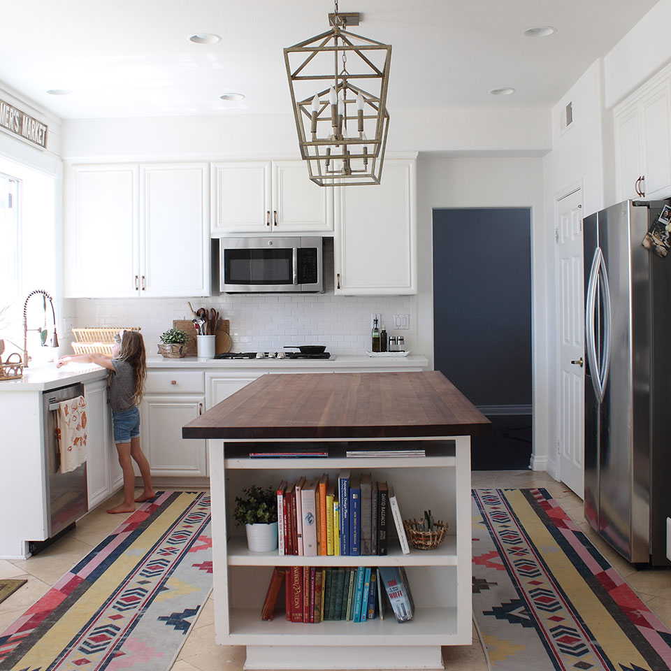 Colorful geometric runner rugs in kitchen with island and pendant light