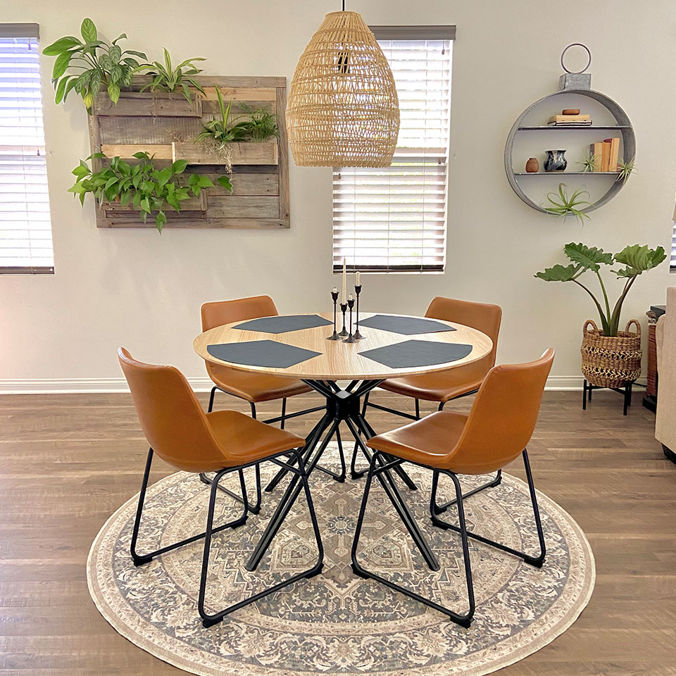 Round table with brown leather chairs on round rug with round wall shelf and basket weave pendant light.jpg