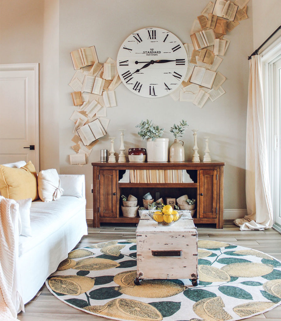 Yellow lemon round rug in living room with round clock and books wall accent.