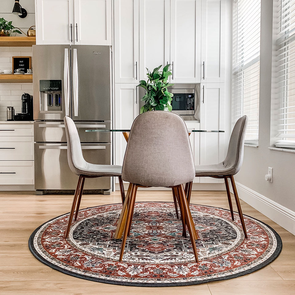 Red and blue persian round rug with midcentury modern chairs and round table in kitchen