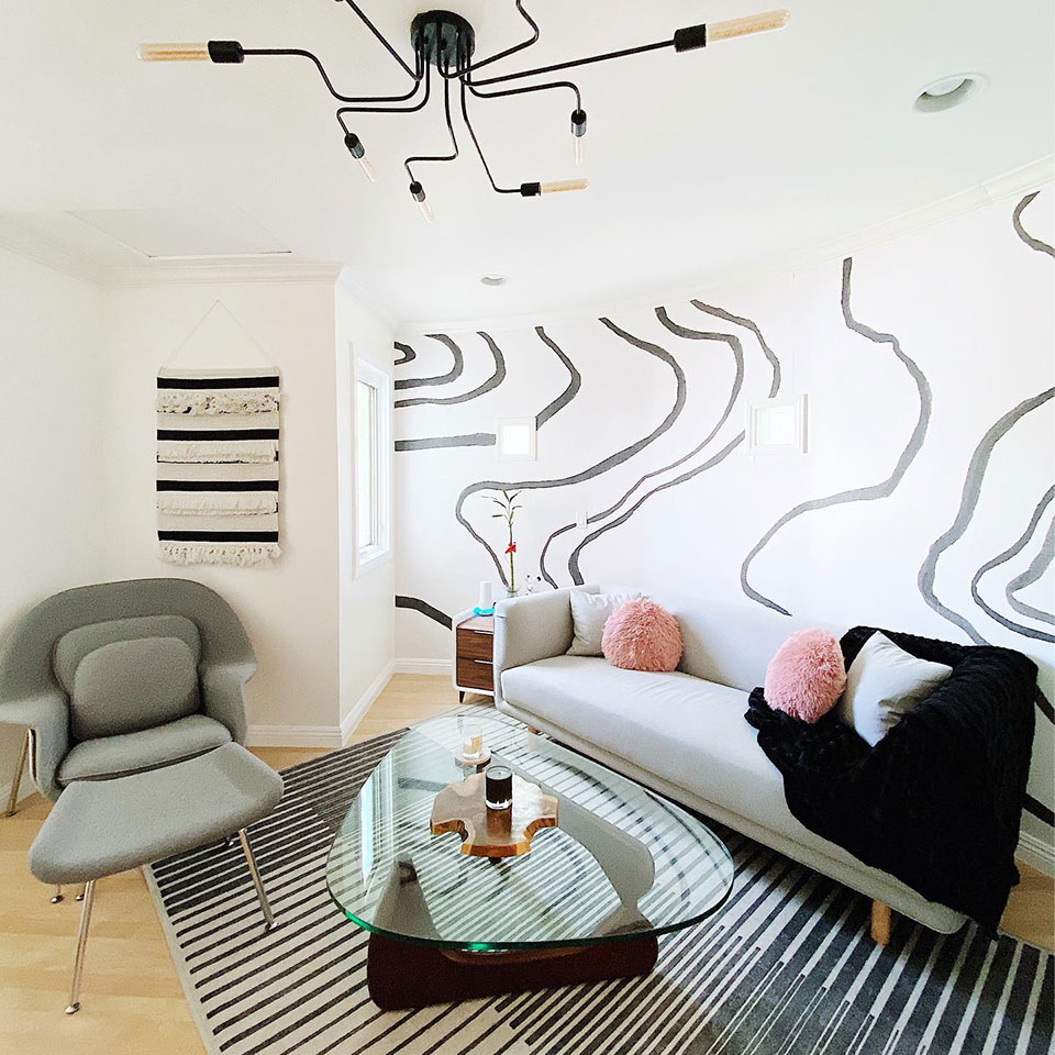 Gradasi grey and white stripe rug in living room with modern furniture, black and gold light, and black and white wallpaper