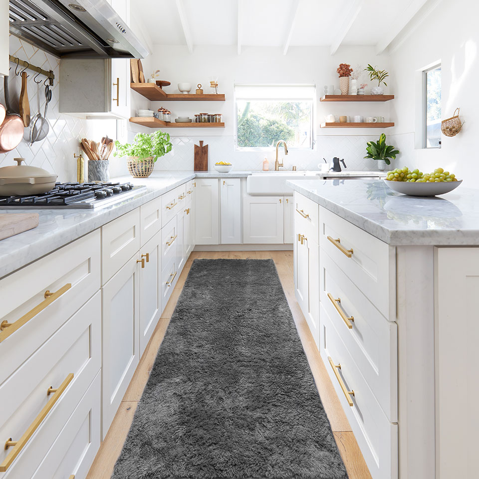 Grey plush runner rug in white kitchen with marble countertop and gold cabinet handles