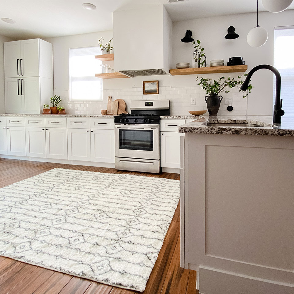White plush rug with geometric patterns in black and white kitchen with plants