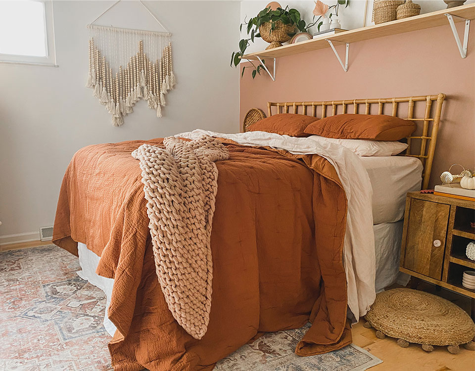 Fall bedroom decor with rust colored sheets and coral rug.