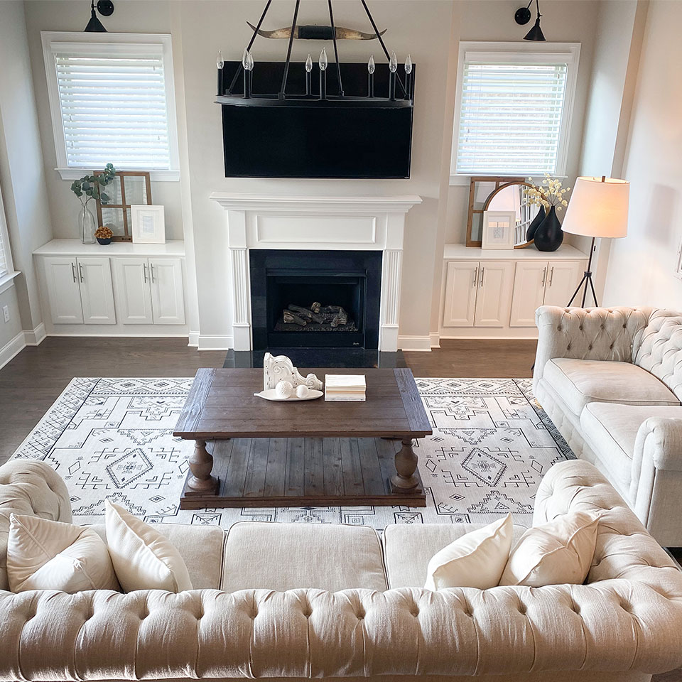 Black and white geometric rug with cream couch by fireplace in the living room