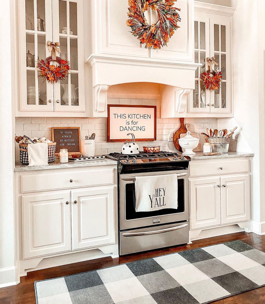 Black and white plaid rug in white kitchen with fall decor