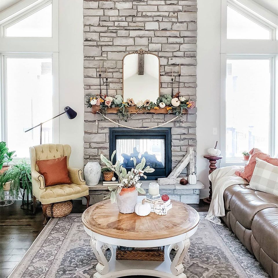 grey persian rug by fireplace in the living room with fall decor