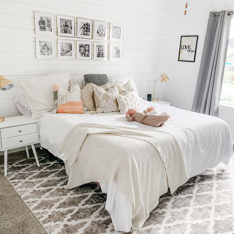 cozy neutral bedroom with grey drapes and wood wall