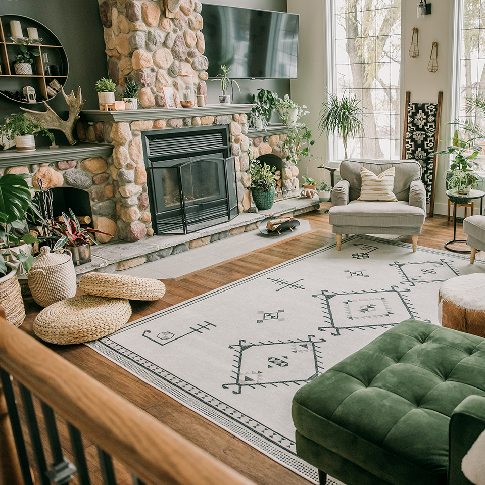 neutral fireplace rug in living room with green velvet sofa and cabin decor