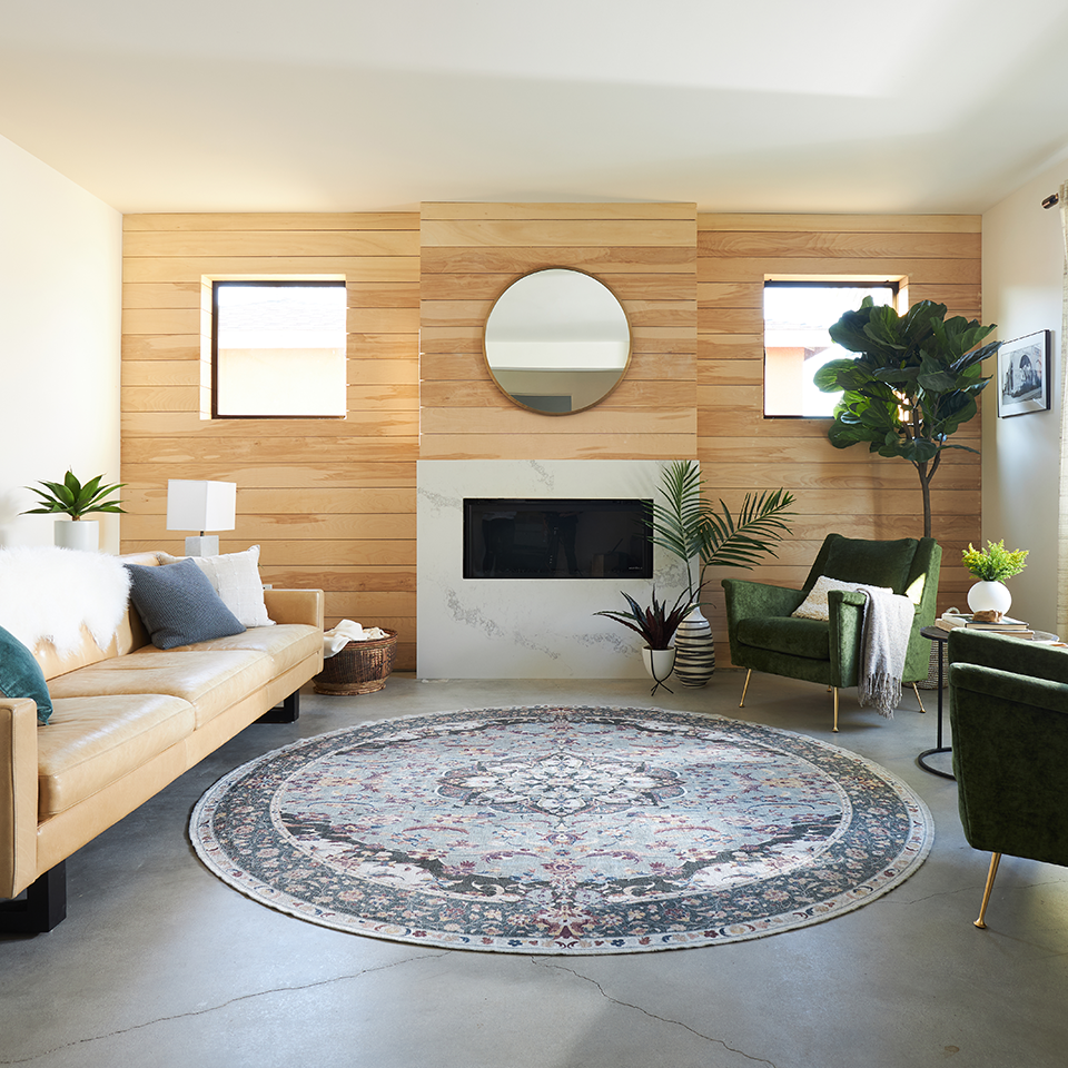 round persian fireplace rug in living room with wood panel wall