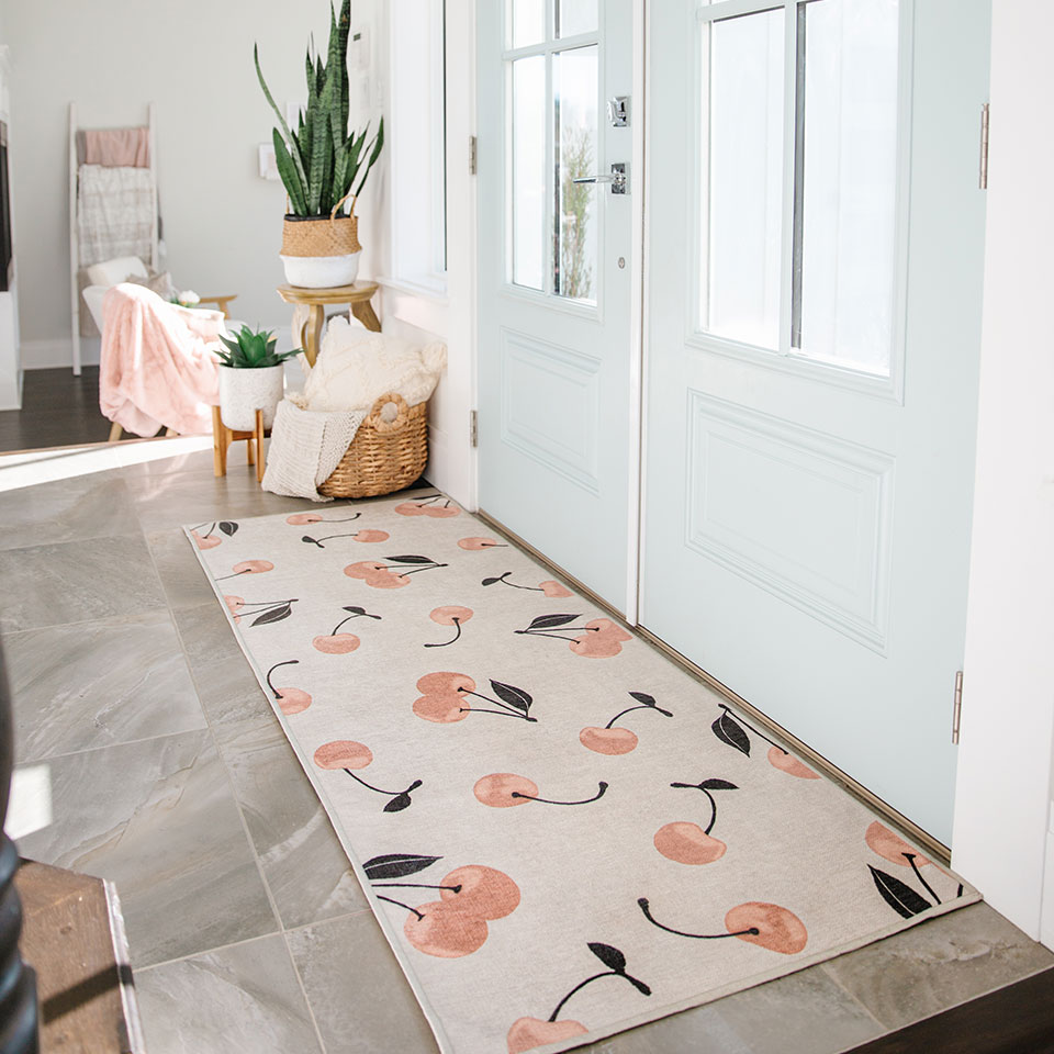 Coral cherry rug on marble floor and light blue door in entryway