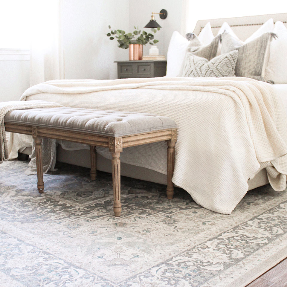 blue and neutral persian rug in neutral bedroom