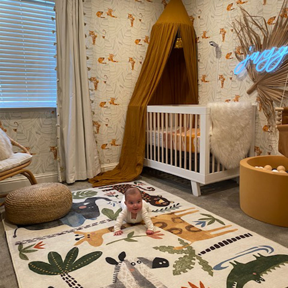 safari nursery rug with patterned wallpaper and boho accents