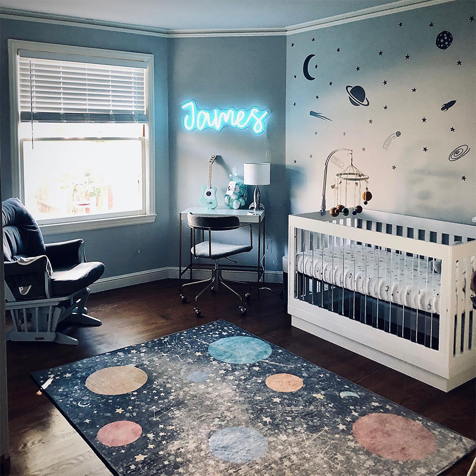 space nursery rug with space decals and white crib
