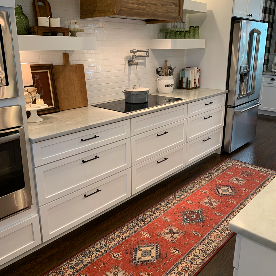 traditional red runner rug in kitchen with white cabinets