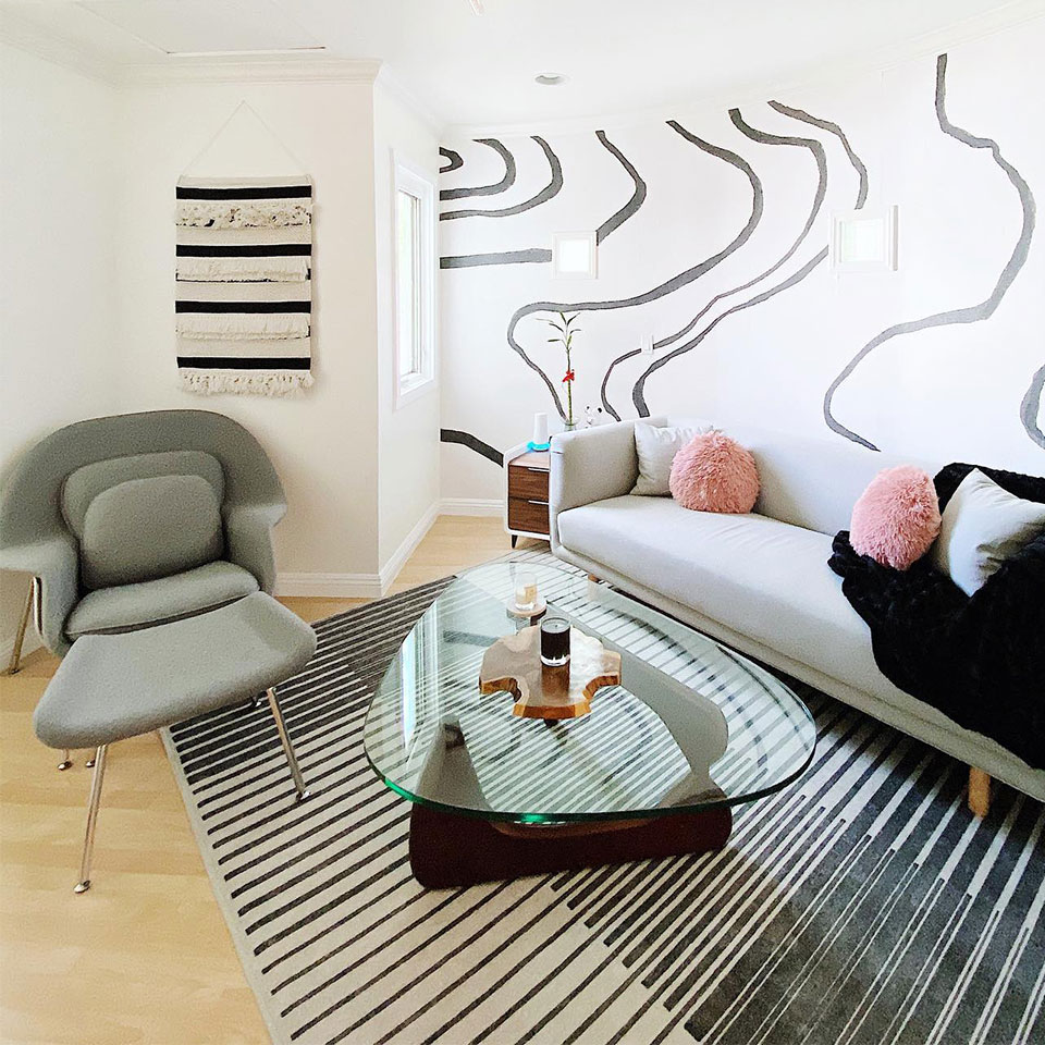 geometric rug in living room with mural wall