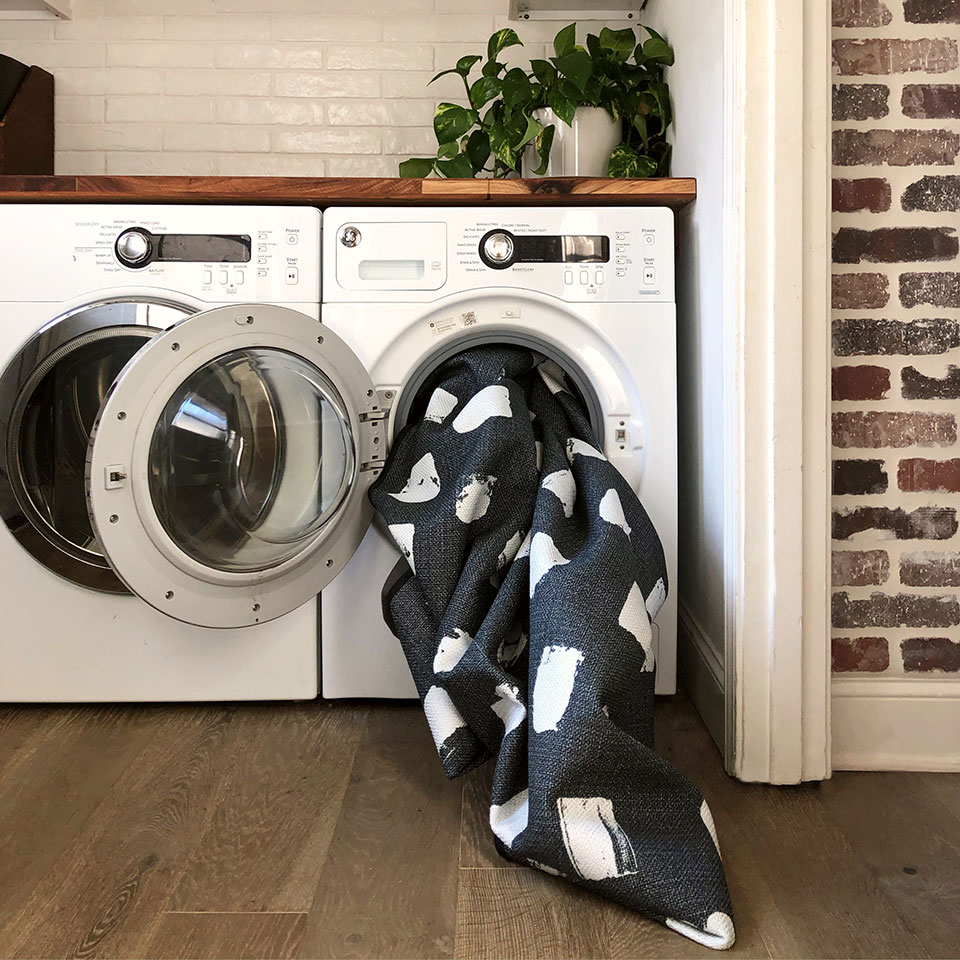 laundry room with black and white rug in washing machine