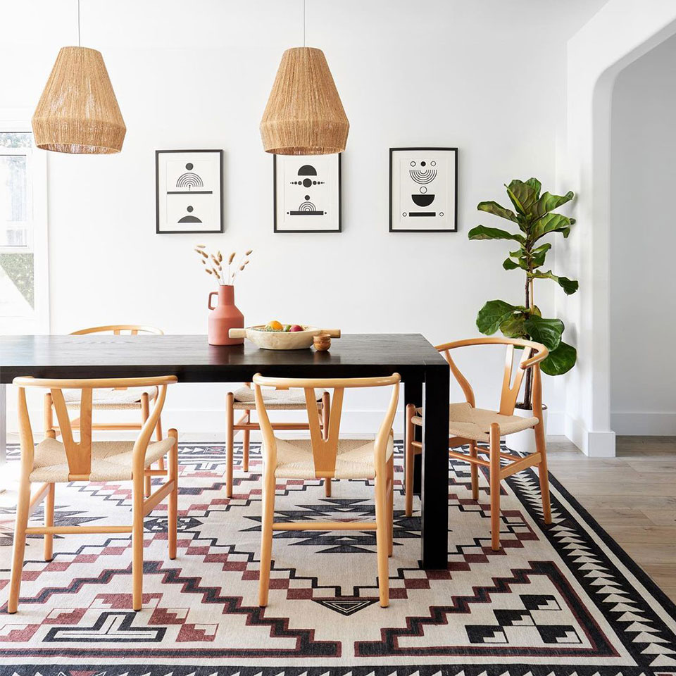 black and white geometric dining room rug under table with plant