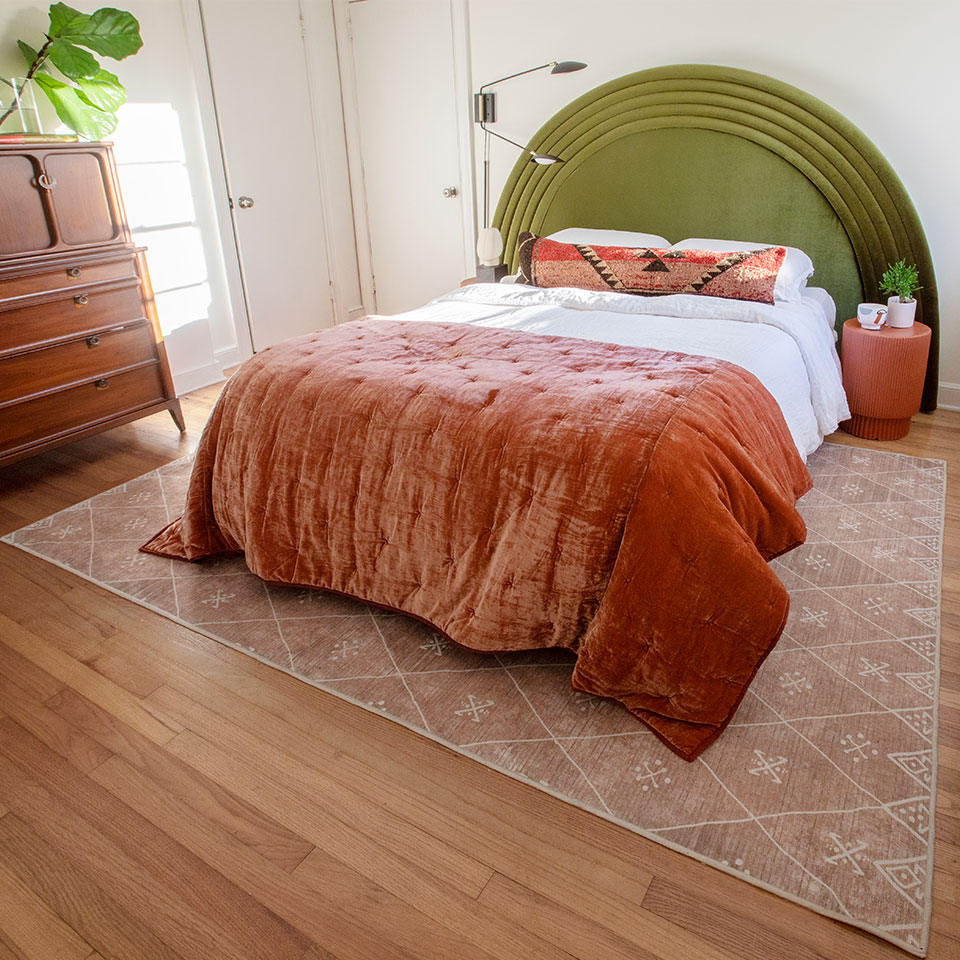 spring pink boho rug in bedroom with green headboard