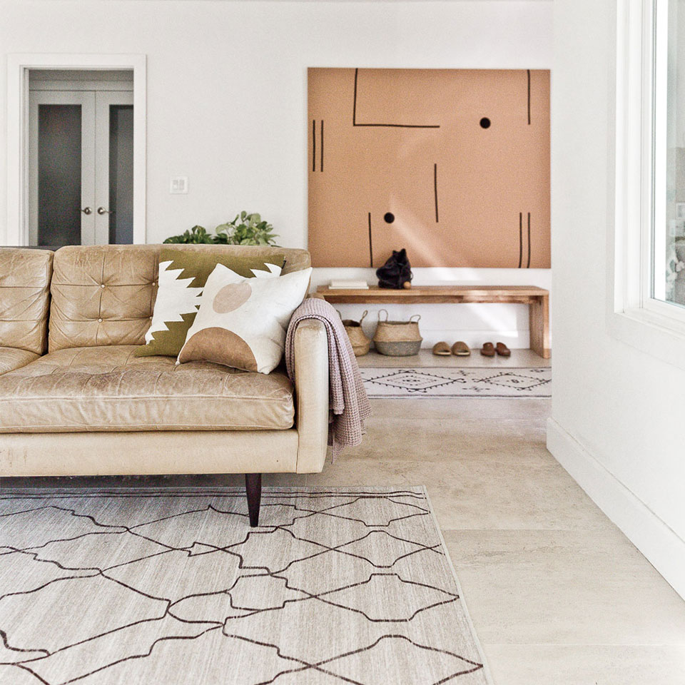 spring tan moroccan rug in living room with tan sofa and neutral decor