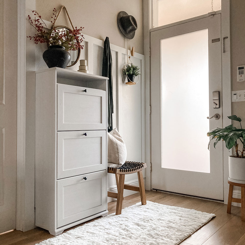 white plush rug in small entryway foyer with white storage cabinet