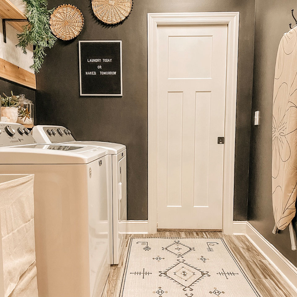 black and white runner rug in laundry room with black walls