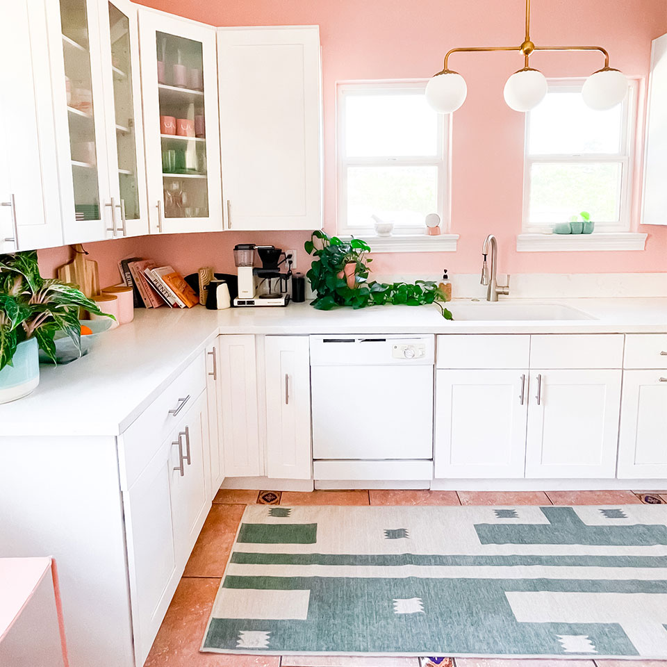 green rug in kitchen with pink walls