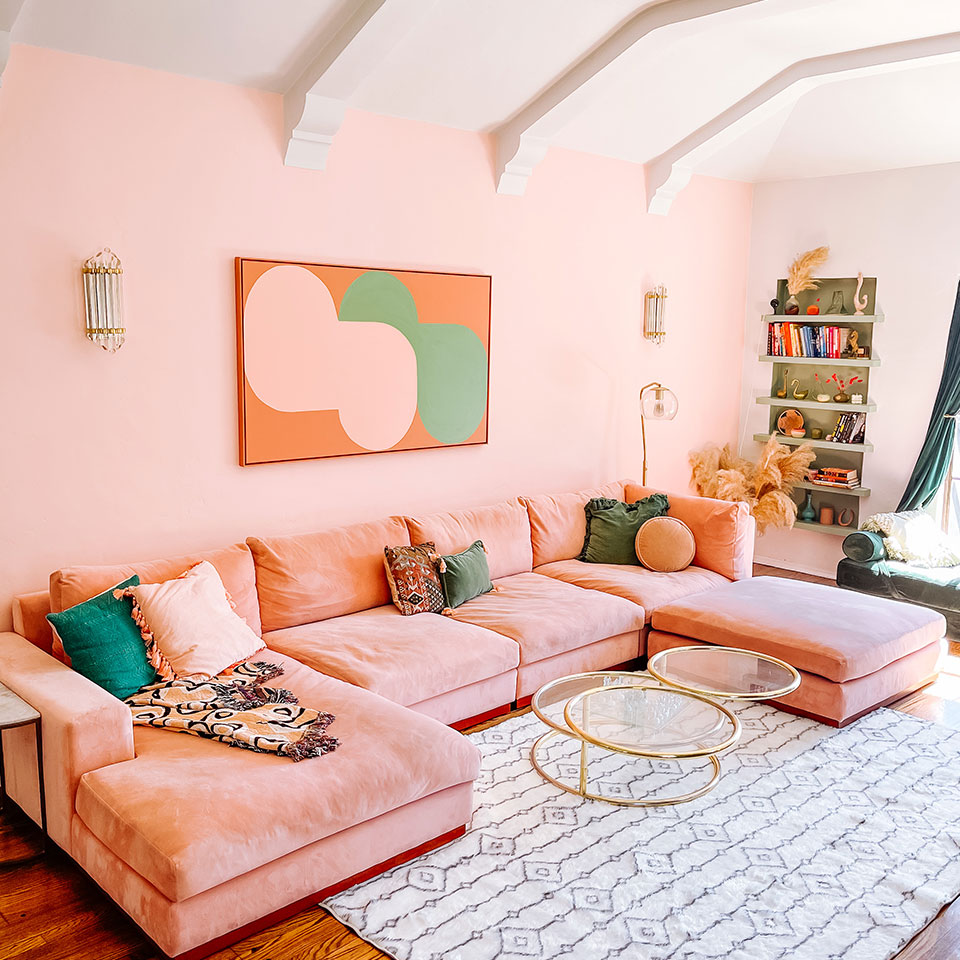 pink couch with black and white rug in living room