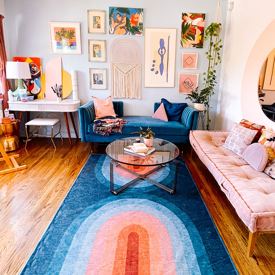 teal rainbow rug in living room with pink sofa