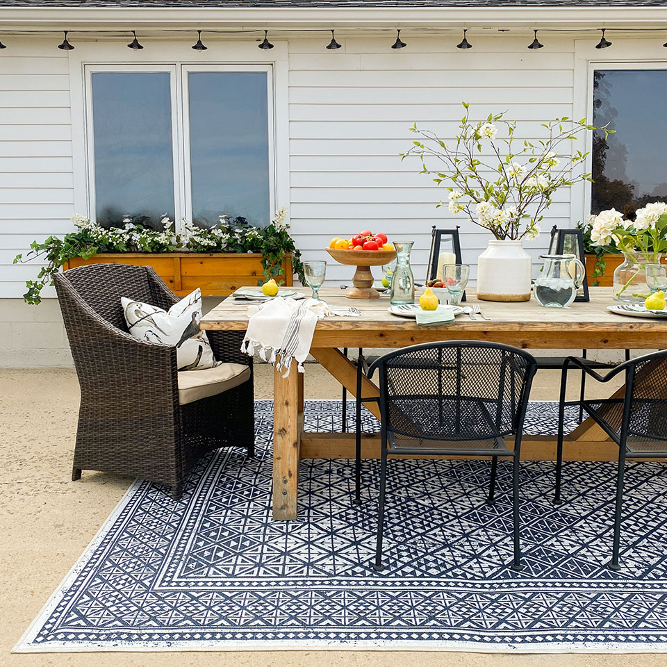 blue and white outdoor rug on patio under dining table