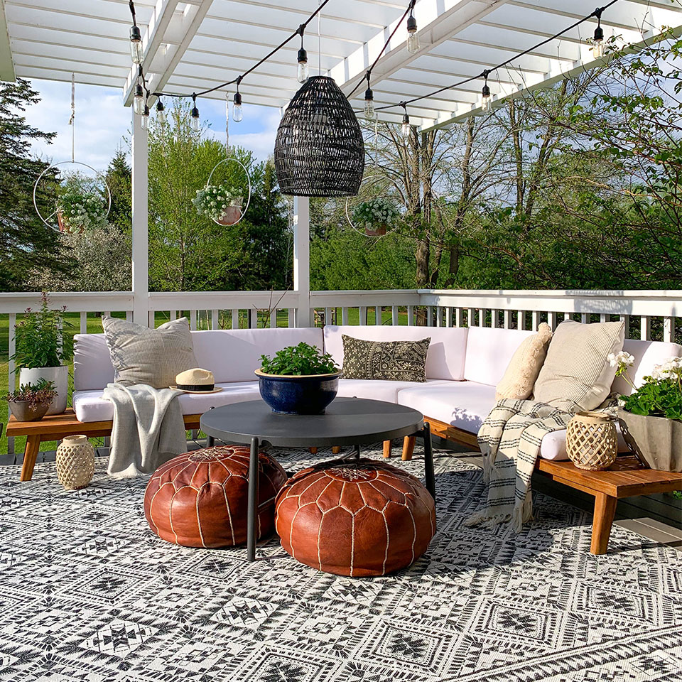 outdoor black and white boho rug on patio with boho furniture
