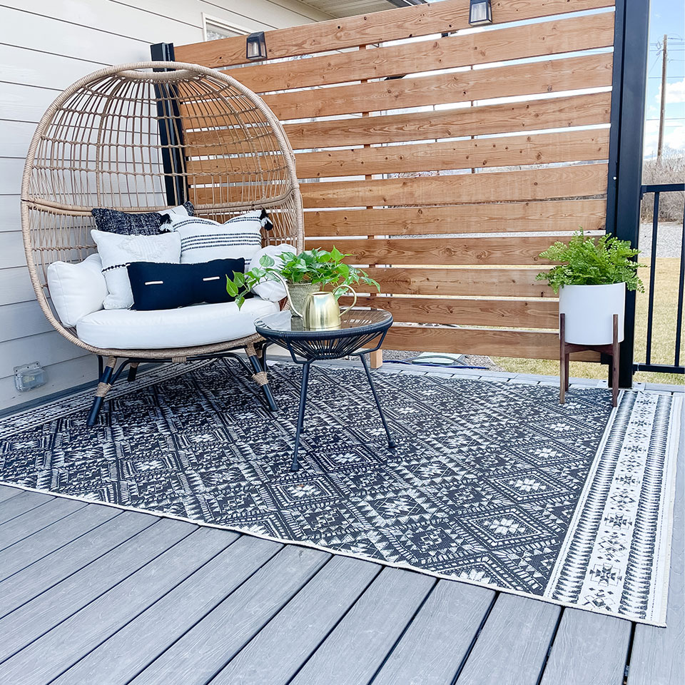 outdoor black and white rug with boho chair and table