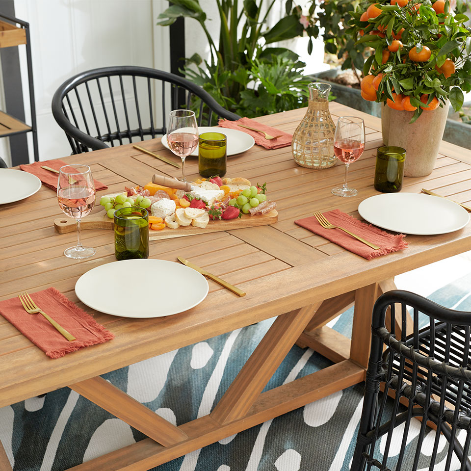 outdoor summer party dining table and palm leaf rug