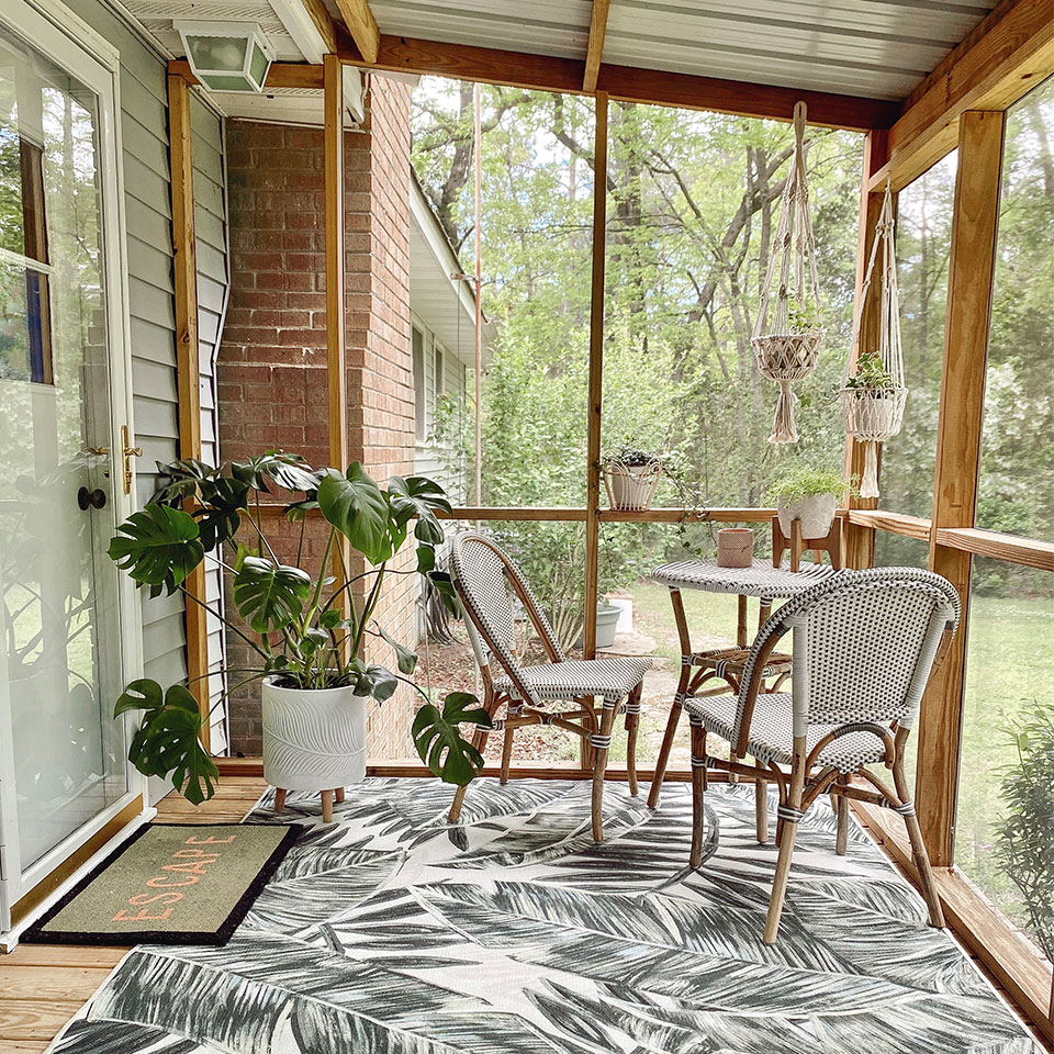 small outdoor palm leaf rug on porch with table and chairs