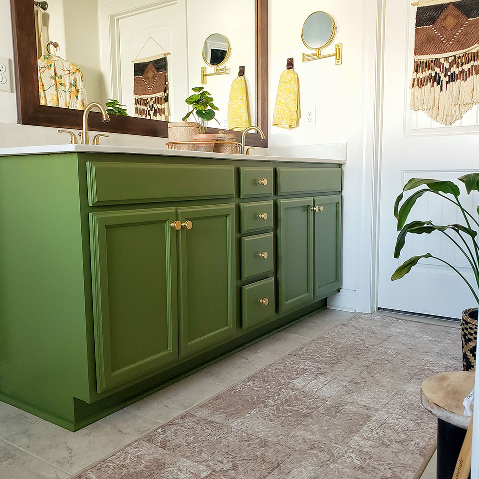 tan boho rug in bathroom with green cabinets