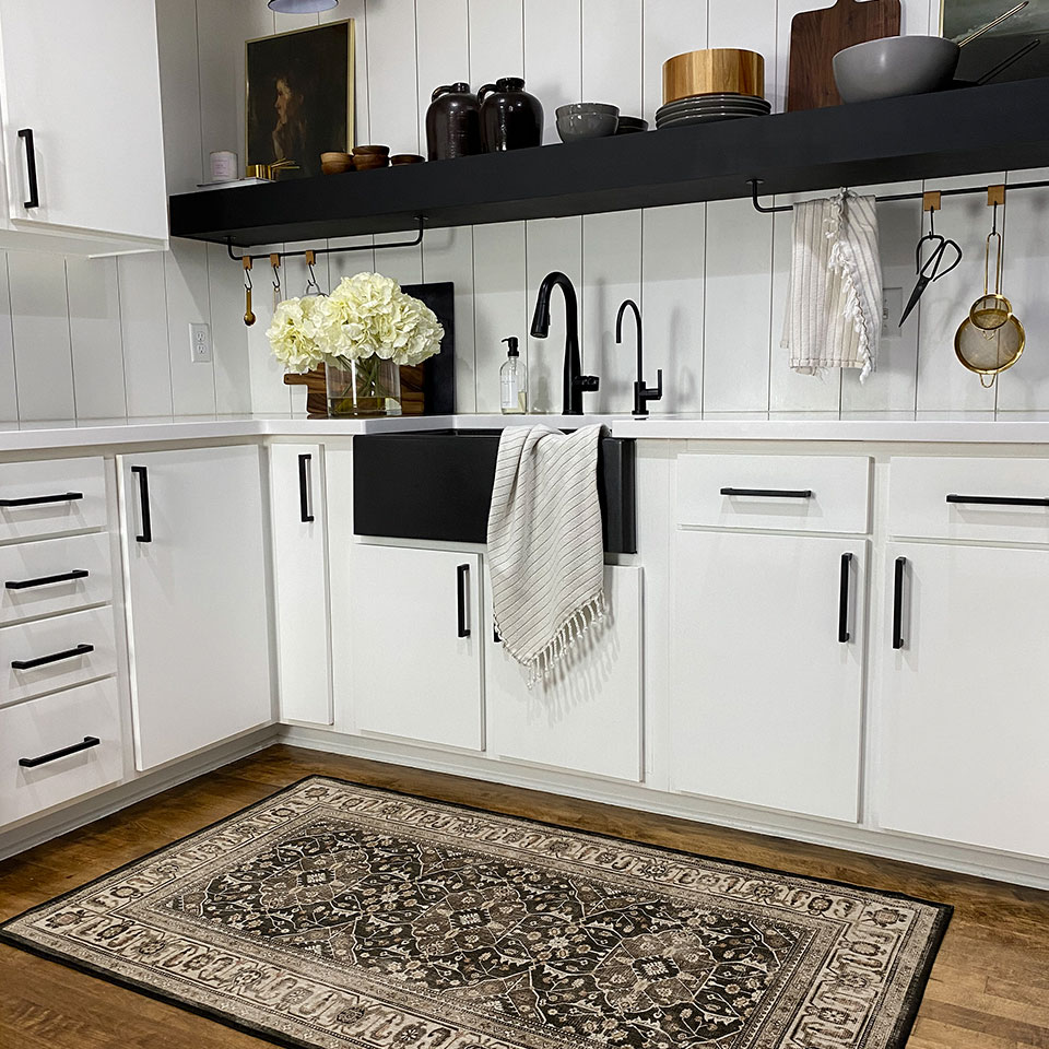 black and brown persian rug in kitchen with white cabinets
