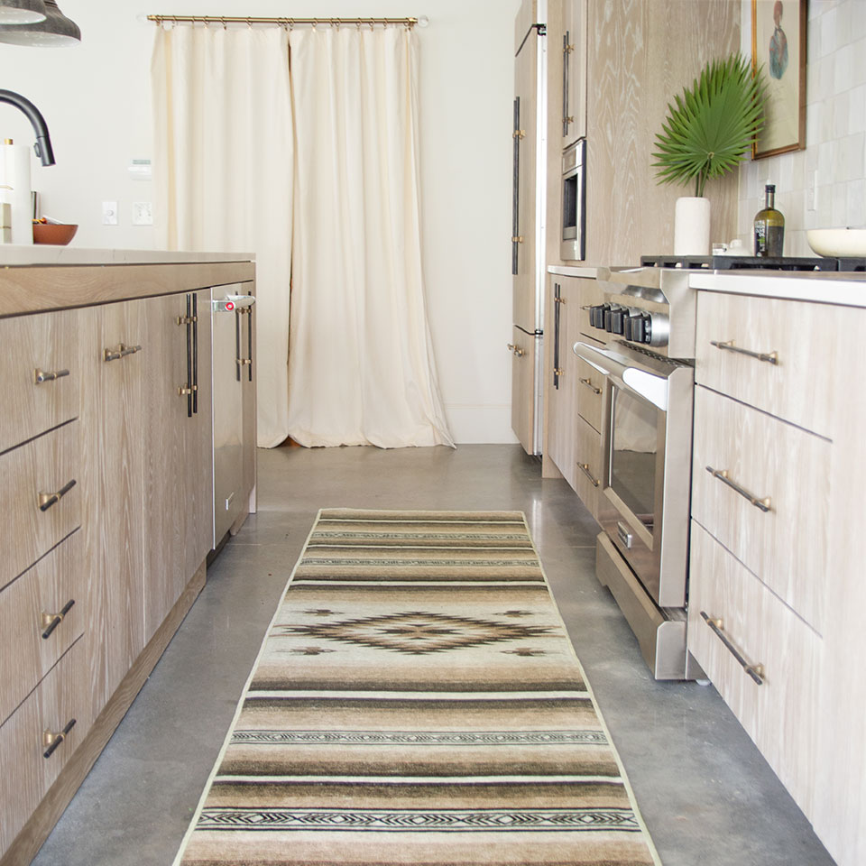 brown southwestern runner rug in kitchen with brown cabinets