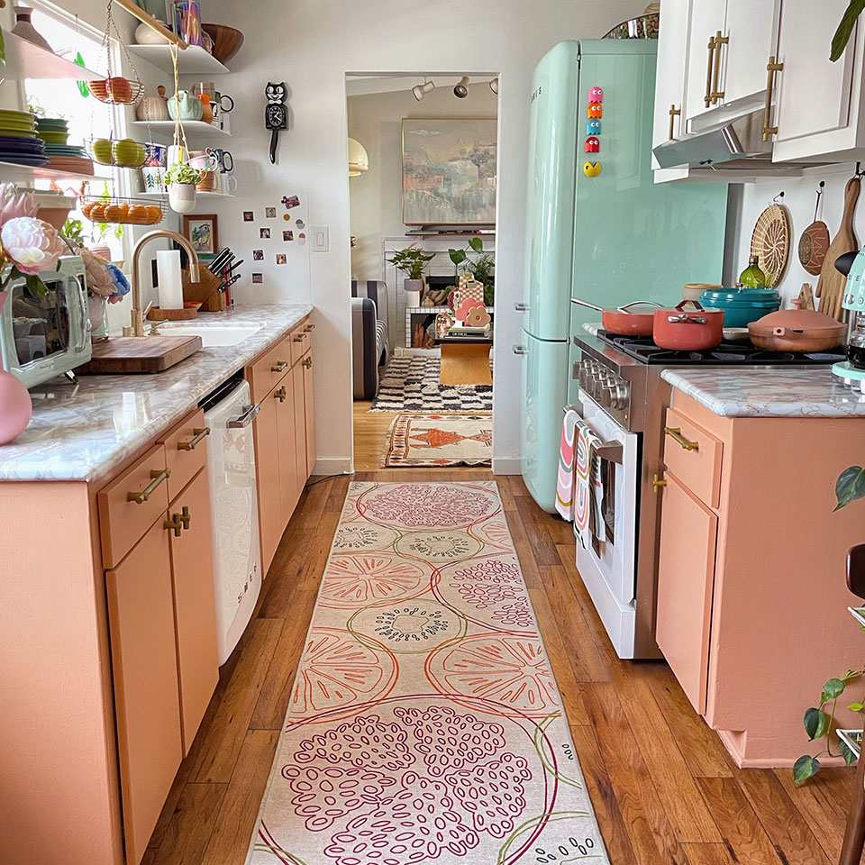 colorful fruit rug in kitchen with pink cabinets