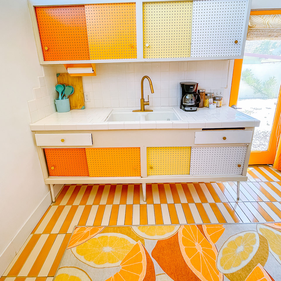 orange citrus rug in kitchen with colorful cabinets
